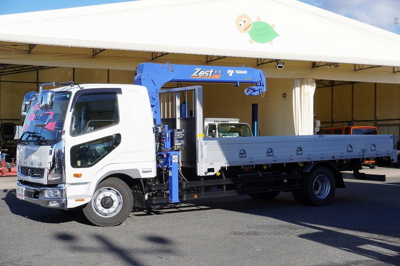 （未使用）　ファイター　増トン　「ワイド　ベッド付き」　４段クレーン　積載７６００ｋｇ　タダノ製　５．５ｍ長　アルミブロック　ラジコン　フックイン　２．９３ｔ吊　差し違いアウトリガー　坂道発進補助　床フック５対　ロープ穴５対　メッキパーツ　衝突軽減ブレーキ　車線逸脱警報　６速ＭＴ！　車検「Ｒ８年２月まで！」フロント画像